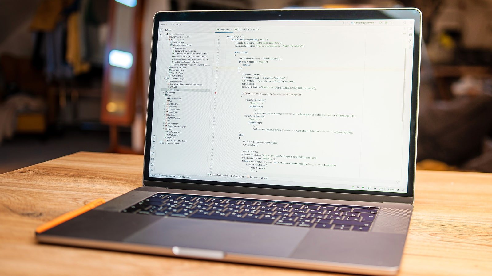 Notebook aberto sobre uma mesa de madeira mostrando código de programação na tela